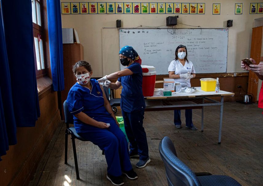 Una maestra recibe la primera dosis de la vacuna para COVID-19, de la china Sinovac Biotech, en una escuela pública en Santiago de Chile.