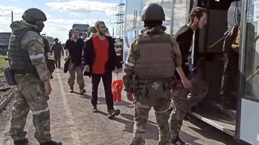 En esta foto tomada de un video distribuido por el Servicio de Prensa del Ministerio de Defensa ruso el martes 17 de mayo de 2022, soldados rusos observan a combatientes ucranianos evacuados de la acería Azovstal en Mariúpol, Ucrania.&nbsp;