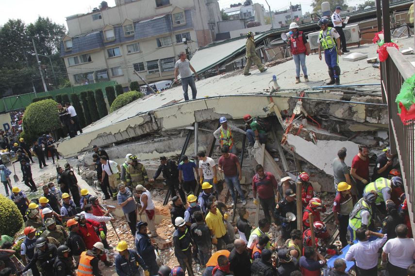 En esta fotografía del 19 de septiembre de 2017, rescatistas buscan a niños atrapados en los escombros de la escuela Enrique Rébsamen, en la Ciudad de México.