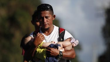 El migrante hondure&ntilde;o Selvin Hern&aacute;ndez lleva en brazos a Mayra Irene, hija de otra migrante, en un grupo de personas que intenta llegar hasta Estados Unidos, cerca de El Cinchado, Guatemala, el mi&eacute;rcoles 15 de enero de 2020, en la frontera con Honduras.&nbsp;