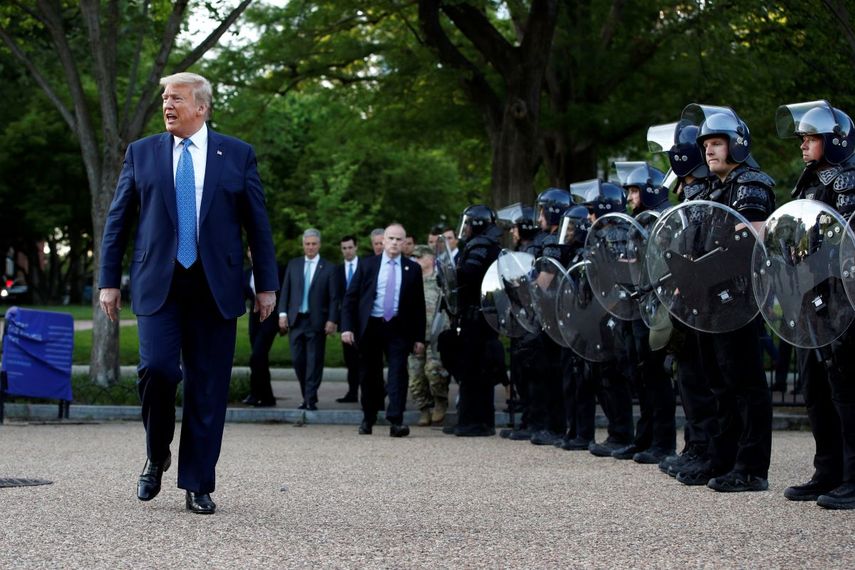El presidente Donald Trump camina el lunes 1 de junio de 2020 junto a agentes policiales en el parque Lafayette frente a la Casa Blanca, en Washington.&nbsp;