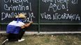Un estudiante hace un grafiti&nbsp; durante una protesta en el campus de la Universidad Centroamericana (UCA) en apoyo a las madres de presos políticos que están en huelga de hambre en la Iglesia San Miguel de Masay. Managua 22 de noviembre de 2019.