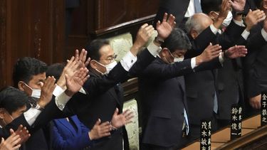 El primer ministro de Japón, Fumio Kishida (centro), y otros legisladores dan tres vivas tras disolver la cámara baja, la más poderosa de las dos del parlamento, durante una sesión extraordinaria, en Tokio, el 14 de octubre de 2021.&nbsp;