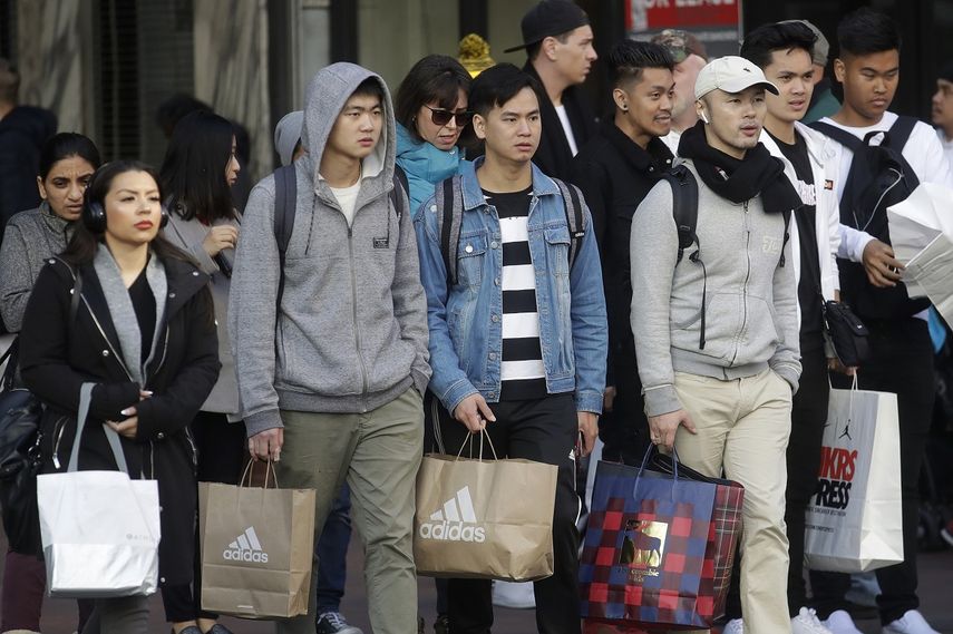 Unas personas cargan bolsas de compras mientras caminan por una calle en San Francisco, el 29 de noviembre de 2019.&nbsp;