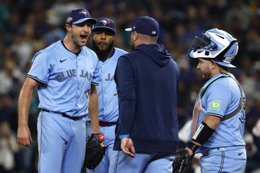 El mánager John Schneider #14 de los Toronto Blue Jays camina hacia el montículo para hablar con Max Scherzer #31 durante la quinta entrada contra los Seattle Mariners en el cuarto juego de la Serie de Campeonato de la Liga Americana en el T-Mobile Park el 16 de octubre de 2025 en Seattle, Washington.&nbsp;