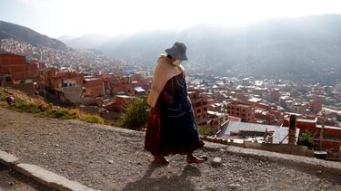Una mujer camina en una calle antes de la apertura de las urnas para las elecciones en El Alto, Bolivia.