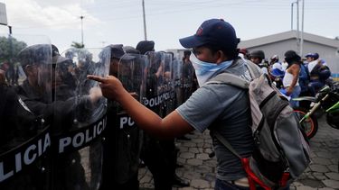 Manifestantes&nbsp;recriminan a los policías antimotines que bloqueen el paso de una marcha contra Daniel Ortega, a quien acusan por la muerte de cientos de personas en protestas contra su régimen.