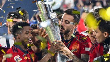 El delantero español Joselu (centro) besa la copa de la Liga de Naciones de la UEFA mientras los jugadores españoles celebran en el podio después de ganar la tanda de penaltis y el partido de fútbol final de la Liga de Naciones de la UEFA entre Croacia y España en el Estadio De Kuip en Róterdam el 18 de junio de 2023. Real El Madrid confirmó la llegada del delantero español Joselu cedido por el descendido Espanyol para la próxima temporada el 19 de junio de 2023.