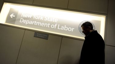 Un hombre pasa ante un letrero en una oficina del Departamento de Trabajo de Nueva York, Estados Unidos