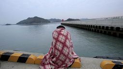Una persona espera noticias de un familiar desaparecido en un puerto de Jindo, Corea del Sur, el miércoles 16 de abril de 2014.