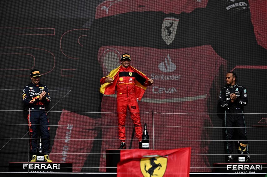 El piloto británico de Mercedes, Lewis Hamilton (der.) y el piloto mexicano de Red Bull Racing, Sergio Pérez (izq.), segundo clasificado, aplauden al piloto español de Ferrari, Carlos Sainz Jr, en el podio de los ganadores después del Gran Premio de Gran Bretaña