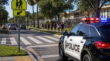 Escena de un cruce peatonal en horario escolar.