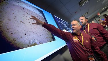 Tom Hoffman (izq.), gerente del Proyecto InSight, junto a Jonny Grinblat (der.), ante la primera imagen llegada de Marte después del aterrizaje con éxito del módulo espacial en la superficie del planeta rojo el 26 de noviembre de 2018.