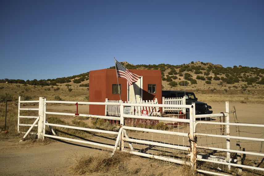Una bandera estadounidense a la entrada del set de filmación de Bonanza Creek Ranch, donde un miembro del equipo recibió un disparo durante la producción de la película occidental Rust, se ve el 28 de octubre de 2021 en Santa Fe, Nuevo México. Armera de filme de Baldwin ignoraba que había balas reales.