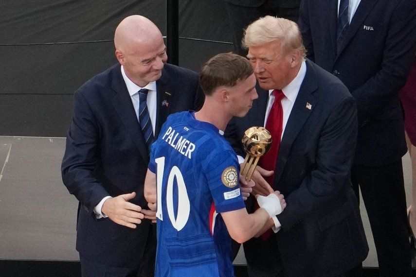 El centrocampista inglés #10 del Chelsea, Cole Palmer (centro), recibe el Balón de Oro de manos del presidente de la FIFA, Gianni Infantino (izq.), y del presidente de los Estados Unidos, Donald Trump (der.), durante la ceremonia de entrega de premios a los campeones de la Copa Mundial de Clubes de la FIFA 2025