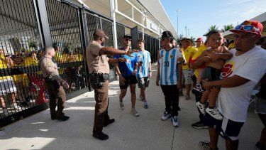 Policías dan instrucciones a los fanáticos afuera del estadio antes de la final de la Copa América entre Argentina y Colombia el domingo 14 de julio de 2024 en Miami Gardens, Florida
