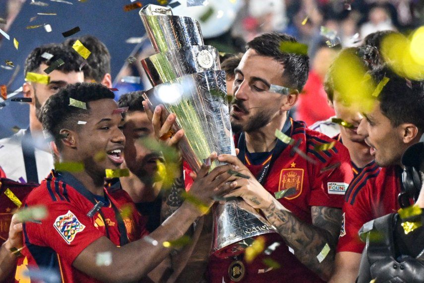 El delantero español Joselu (centro) besa la copa de la Liga de Naciones de la UEFA mientras los jugadores españoles celebran en el podio después de ganar la tanda de penaltis y el partido de fútbol final de la Liga de Naciones de la UEFA entre Croacia y España en el Estadio De Kuip en Róterdam el 18 de junio de 2023. Real El Madrid confirmó la llegada del delantero español Joselu cedido por el descendido Espanyol para la próxima temporada el 19 de junio de 2023.