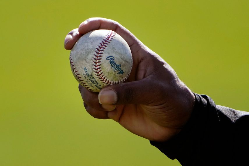 ARCHIVO - Un pitcher de los Rockies de Colorado muestra cómo sujeta la pelota durante un entrenamiento de pretemporada en Scottsdale, Arizona, el 24 de febrero de 2021