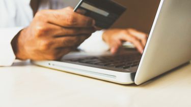 Un hombre realiza una transferencia de dinero online.