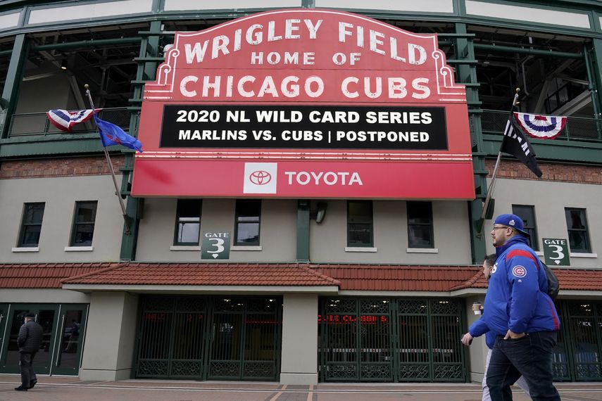 Peatones frente al estadio Wrigley Field de los Cachorros de Chicago, equipo de las Grandes Ligas, el jueves 1 de octubre de 2020