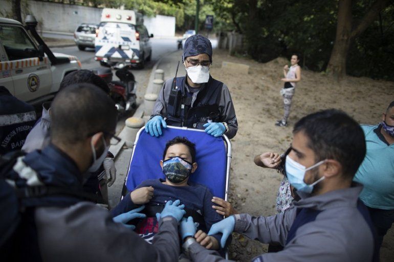 Voluntarios de Ángeles de las Vías transportan en camilla a un niño que resultó lesionado en un accidente con una motocicleta en Caracas el 4 de febrero del 2021. 