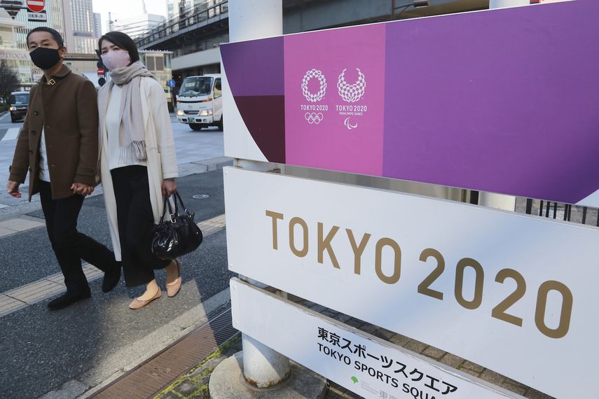 Peatones frente a un cartel publicitario de los Juegos Olímpicos de Tokio, el martes 16 de febrero de 2021.&nbsp;