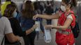 Pasajeros recibiendo mascarillas repartidas por voluntarios de Cruz Roja en una estaci&oacute;n de tren de Barcelona, Espa&ntilde;a, el lunes 4 de mayo de 2020.&nbsp;
