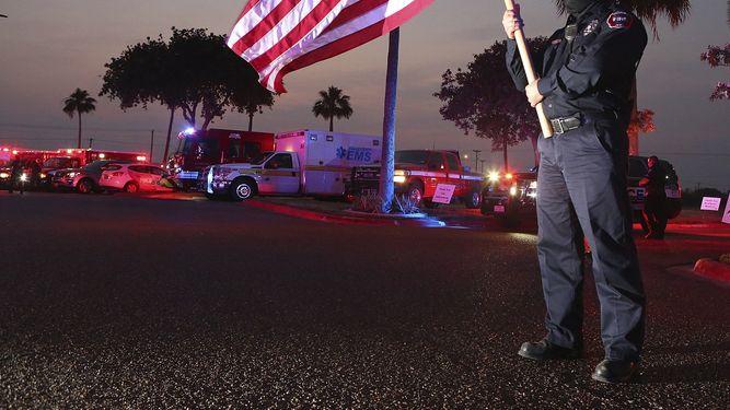 Homer Garza, bombero en Edinburg, ondea una bandera de Estados Unidos mientras los equipos de emergencias de la ciudad muestran su apoyo al personal m&eacute;dico y a sus pacientes, en el centro m&eacute;dico regional de Edinburg, el 22 de abril de 2020 en Edinburg, Texas.&nbsp;