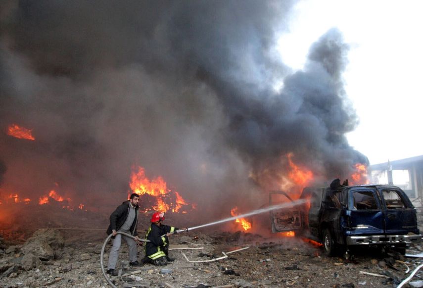 Personal de emergencias trata de apagar un vehículo en llamas en Beirut, el lunes 14 de febrero de 2005.&nbsp;