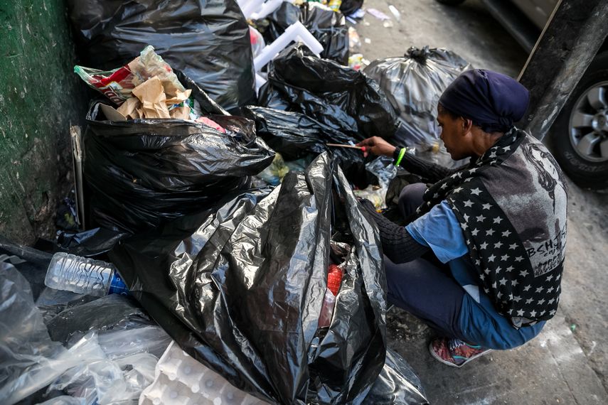 Una mujer hurga en una basura en busca de comida en una calle de Caracas (Venezuela), una imagen que se repite cada vez más y que resume una cosa: el hambre que padecen los sectores más vulnerables.