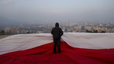 Manifestantes chilenos se colocaron, sobre una bandera gigante antes de una manifestación en contra de la nueva Constitución propuesta para el país, en Santiago, Chile, el 1 de septiembre de 2022.&nbsp;