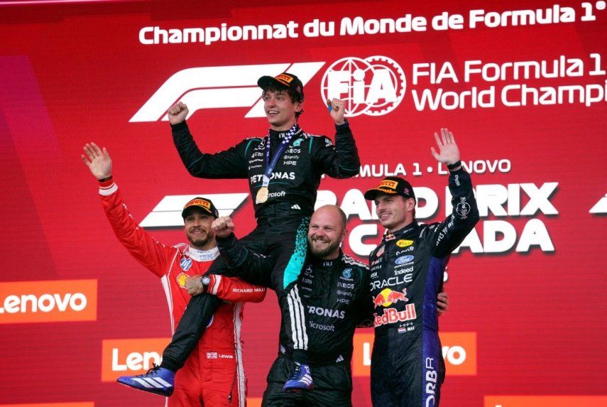 El piloto italiano Kimi Antonelli, ganador de la carrera Mercedes, es levantado por el piloto británico Lewis Hamilton (izquierda) y el técnico compuesto por equipos senior de carreras de Mercedes, Dean Hale, cuando el piloto holandés Max Verstappen, se une a la celebración en el podio al final del Gran Premio de Fórmula 1 de Canadá de 2026