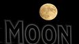 La luna se eleva más allá de un letrero en el estadio durante la quinta entrada de un partido de béisbol entre los Kansas City Royals y los Chicago White Sox el miércoles 10 de agosto de 2022, en Kansas City, Mo.&nbsp;