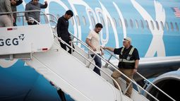 Migrantes de distintas nacionalidades, procedentes de Estados Unidos, descienden de un avión en el Aeropuerto Internacional Juan Santamaría en San José (Costa Rica)