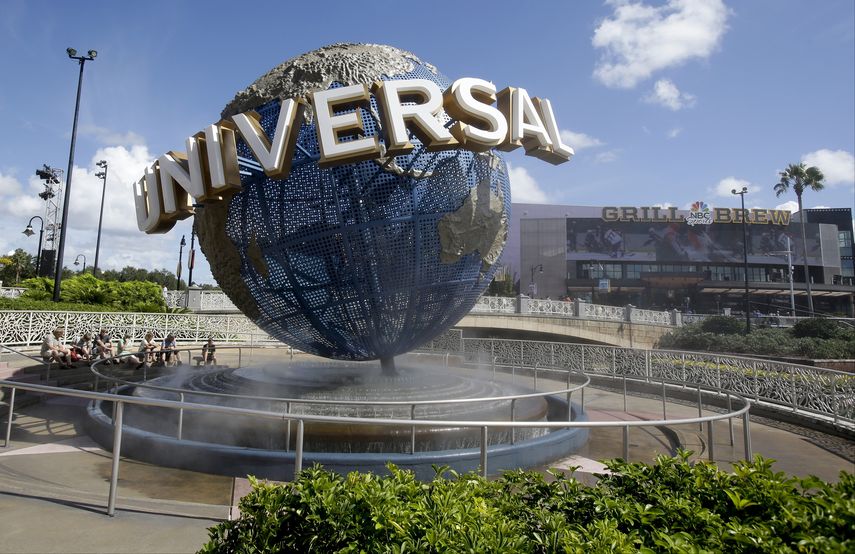 Unos visitantes toman una pausa bajo la brisa del globo en Universal Studios City Walk en Orlando, Florida.