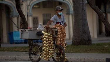 Un hombre con una mascarilla protectora vende ajos y cebollas en La Habana, Cuba, el jueves 30 de diciembre de 2021, en medio de la nueva pandemia de coronavirus.&nbsp;