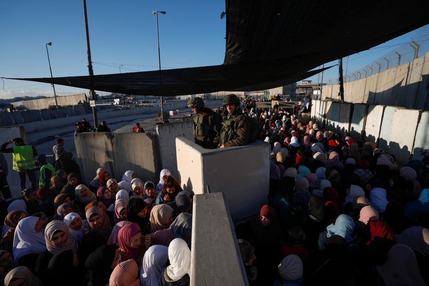 Palestinos pasan por el puesto de control israelí de Kalandia mientras se dirigen a la mezquita Al-Aqsa para asistir a los rezos del primer viernes del mes del Ramadán, este viernes en Jerusalén (Israel).