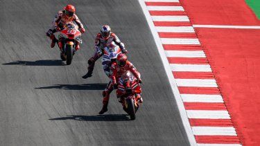 Marc Marquez de Honda conduce junto a Francesco Bagnaina de Ducati, durante la clasificación del GP de Portugal en la Moto GP