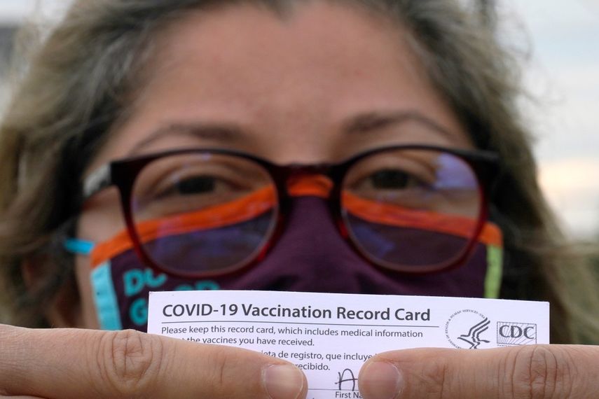 Alejandra, una dentista mexicana y que pidió no revelar su apellido, posa con su tarjeta de vacunación después de recibir la segunda dosis de la vacuna de Moderna contra el COVID-19.