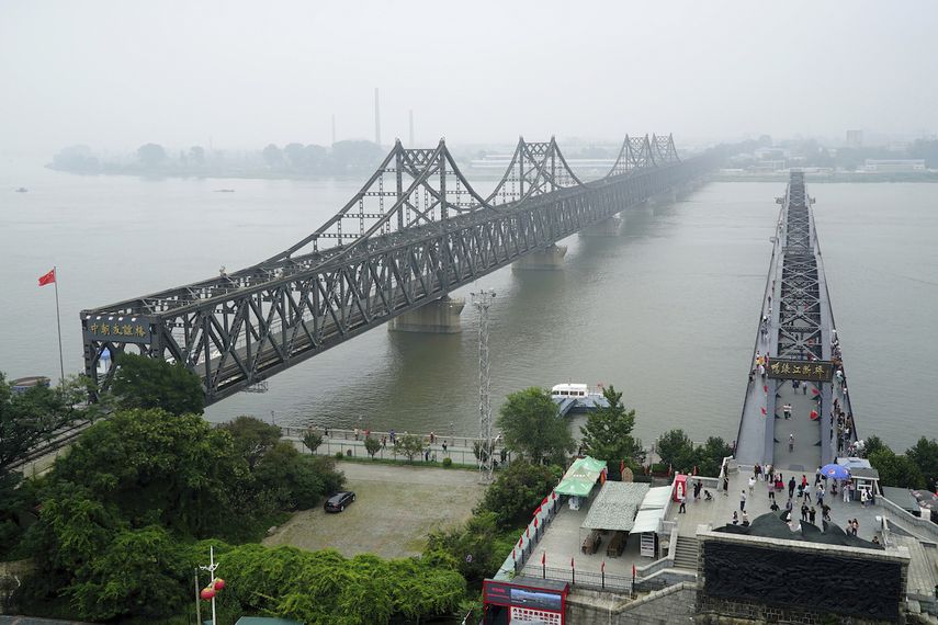 Visitantes caminando por el puente roto del río Yalu, a la derecha, junto al Puente de la Amistad, que conecta China y Corea del Norte, en Dadong, en la provincia nororiental china de Liaoning, el 9 de septiembre de 2017.&nbsp;