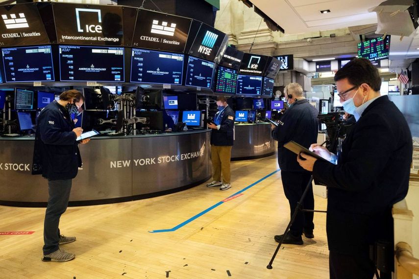 Agentes en Wall Street trabajan en el piso de remate.