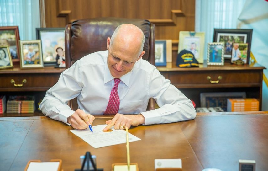 El gobernador Rick Scott firma la proclama que declara a los Knights, de la Universidad Central de la Florida, como campeón nacional del fútbol americano universitario.