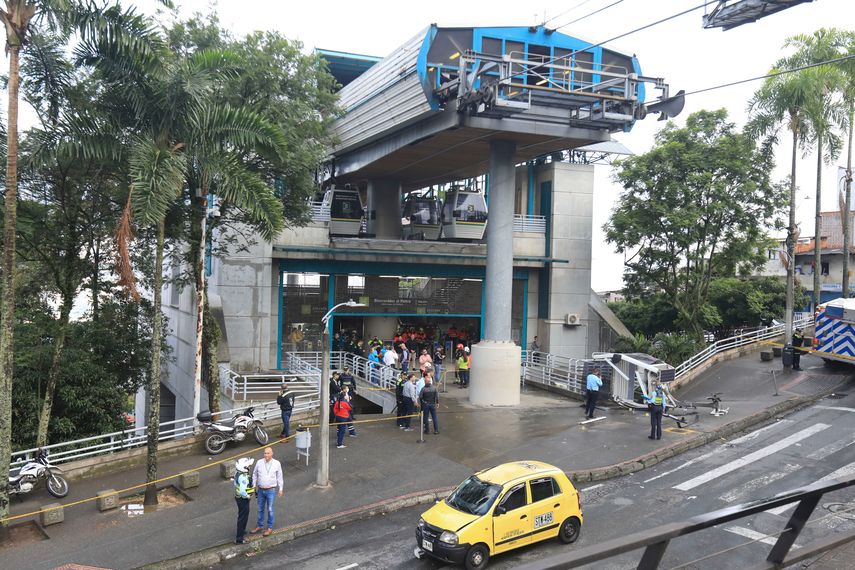 Un teleférico yace en el suelo, a la derecha, después de caer en Medellín, Colombia, el miércoles 26 de junio de 2024. Al menos una persona murió y otras 12 resultaron heridas cuando el teleférico se desplomó mientras se acercaba a una estación, dijeron las autoridades locales. 