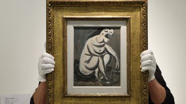 Un asistente de galería sostiene la pintura de Pablo Picasso Nu accroupie durante una vista previa de prensa en la casa de subastas Phillips en Londres el 12 de octubre de 2023. El Centro Pompidou de París abrió una nueva exposición del artista. &nbsp;