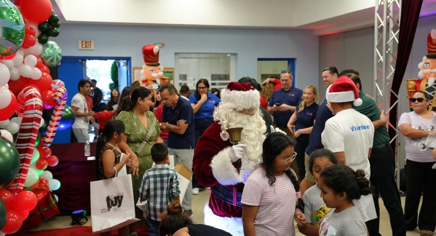 Asistentes interactuando con Santa Claus durante la entrega de juguetes.