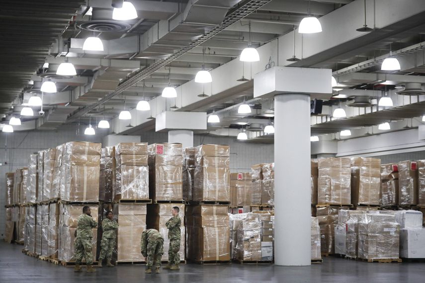 Miembros de la Guardia Nacional permanecen junto a cajas de suministros m&eacute;dicos en el Centro Jacob Javits, el lunes 23 de marzo de 2020, en Nueva York.