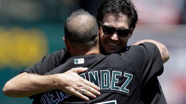 El exlanzador de los Atléticos de Oakland, Barry Zito, abraza al venezolano Ramón Hernández luego de realizar el pitcheo ceremonial, el 1 de julio de 2017.