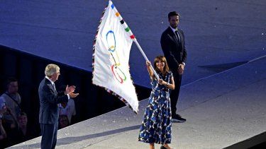 La alcaldesa de París, Anne Hidalgo, eleva la bandera olímpica al lado del presidente del COI, Thomas Bach, el 11 de agosto de 2024.