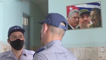 Los policías cubanos Omar Herrera y Youbel Laffita con un cuadro de Díaz-Canel, Fidel y Raúl Castro.&nbsp;