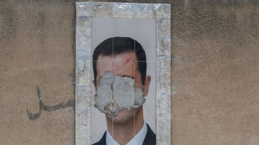 Un retrato desfigurado del derrocado presidente sirio, Bashar al-Assad, cuelga en una pared de la capital, Damasco, el 2 de junio de 2025.